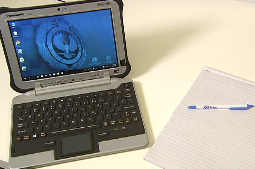 A SA police note taking device next to a pad and pen