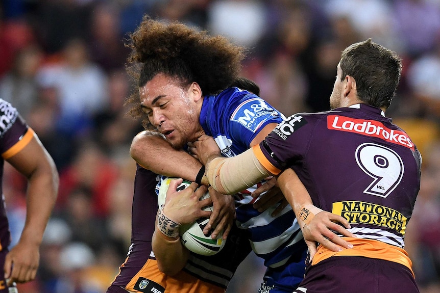 Raymond Faitala is tackled by the Broncos.