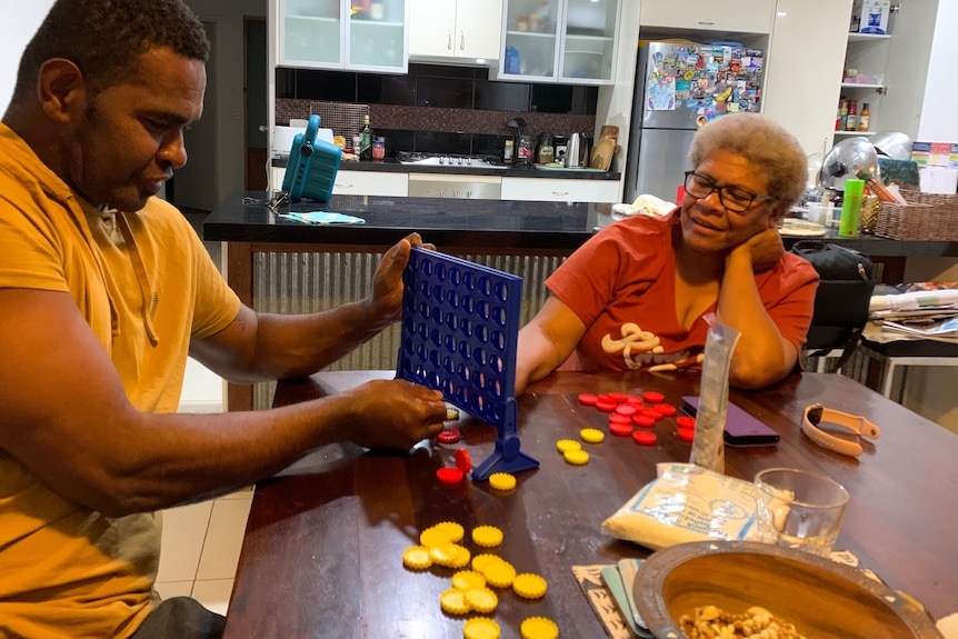 Man and woman playing connect four  