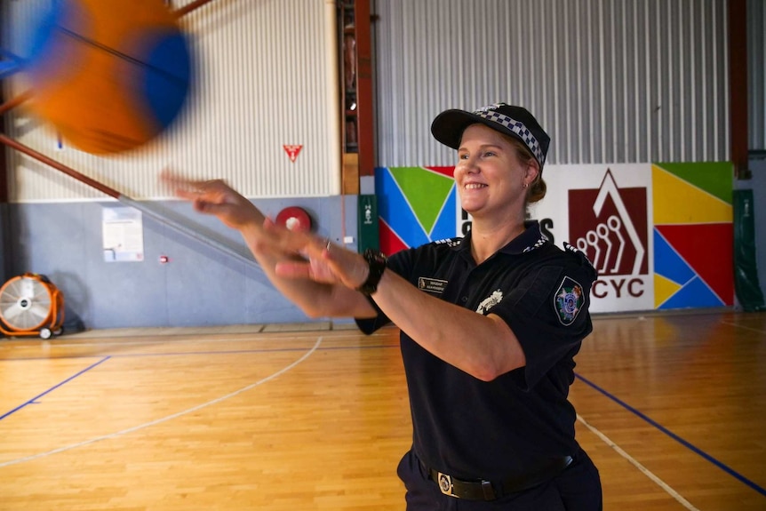 Sergeant Julia Henderson throws a basketball to someone out of the frame.
