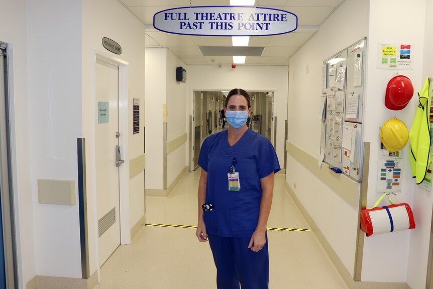 Melinda Daniels wearing navy blue scrubs standing inside her hospital