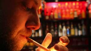 A man smoking a cigarette in a bar