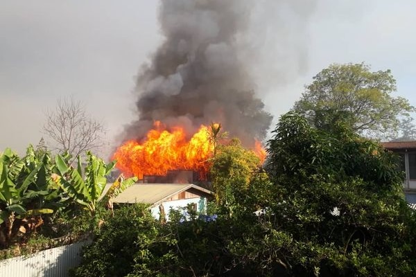 Flames and smoke rose from a house burning in the town of Goroka.