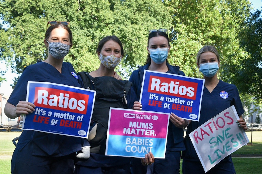 four women wearing navy scrubs holding signs that say 'ratios'