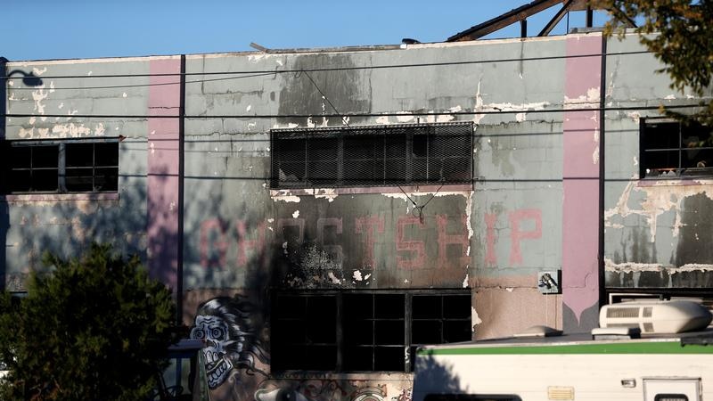 A charred wall is seen outside a warehouse
