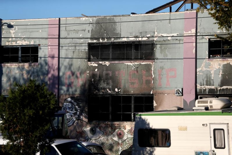 A charred wall is seen outside a warehouse