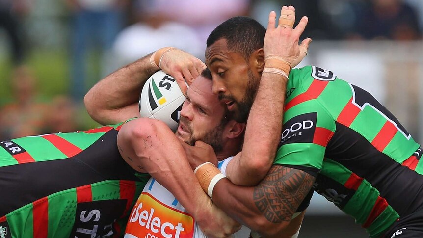 Tight contest ... Nate Miles is tackled by the Rabbitohs