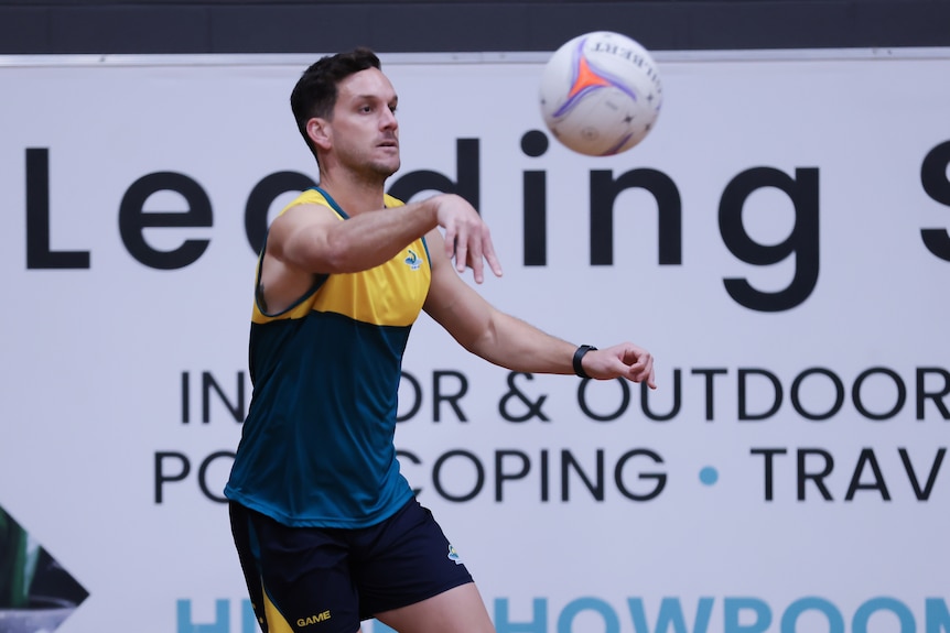 Australian Opens Mens Netball athlete Dylan Nexhip passes a ball during match play at training camp .