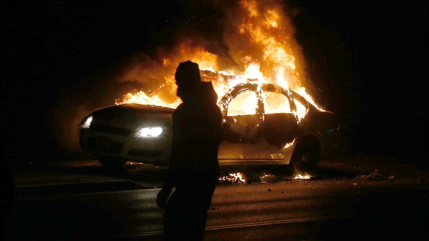 A car burns during protests in Ferguson