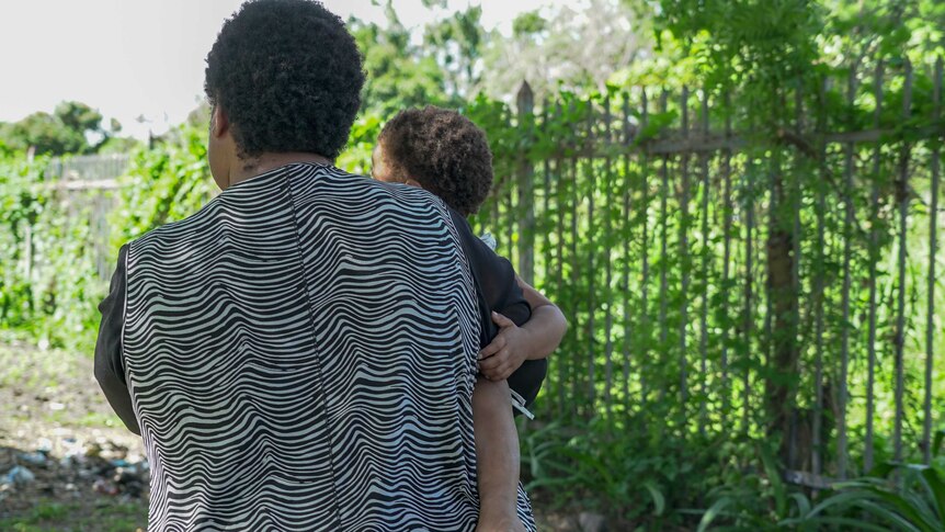 A Papua New Guinean woman holding a small child