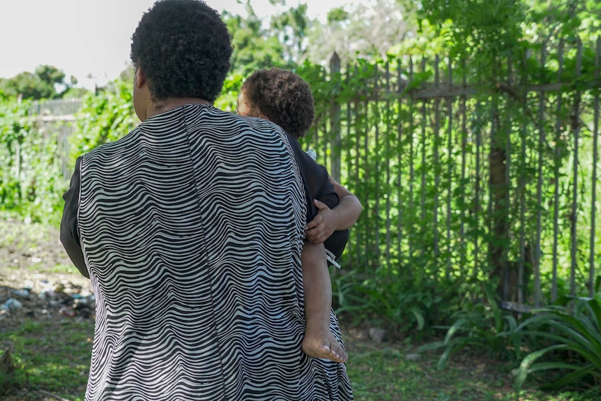 A Papua New Guinean woman holding a small child