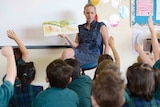 A primary school teacher reads to her class.