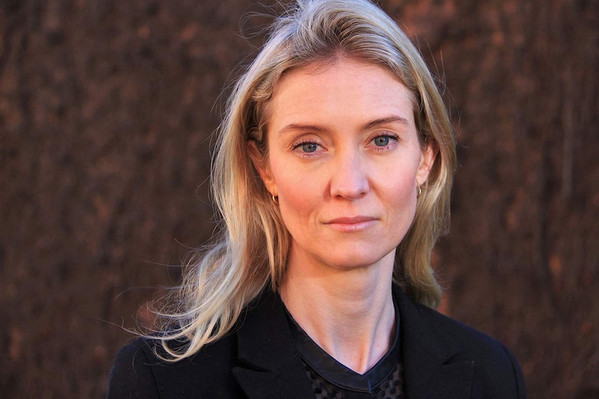 A portrait shot of a blonde woman wearing a black shirt.