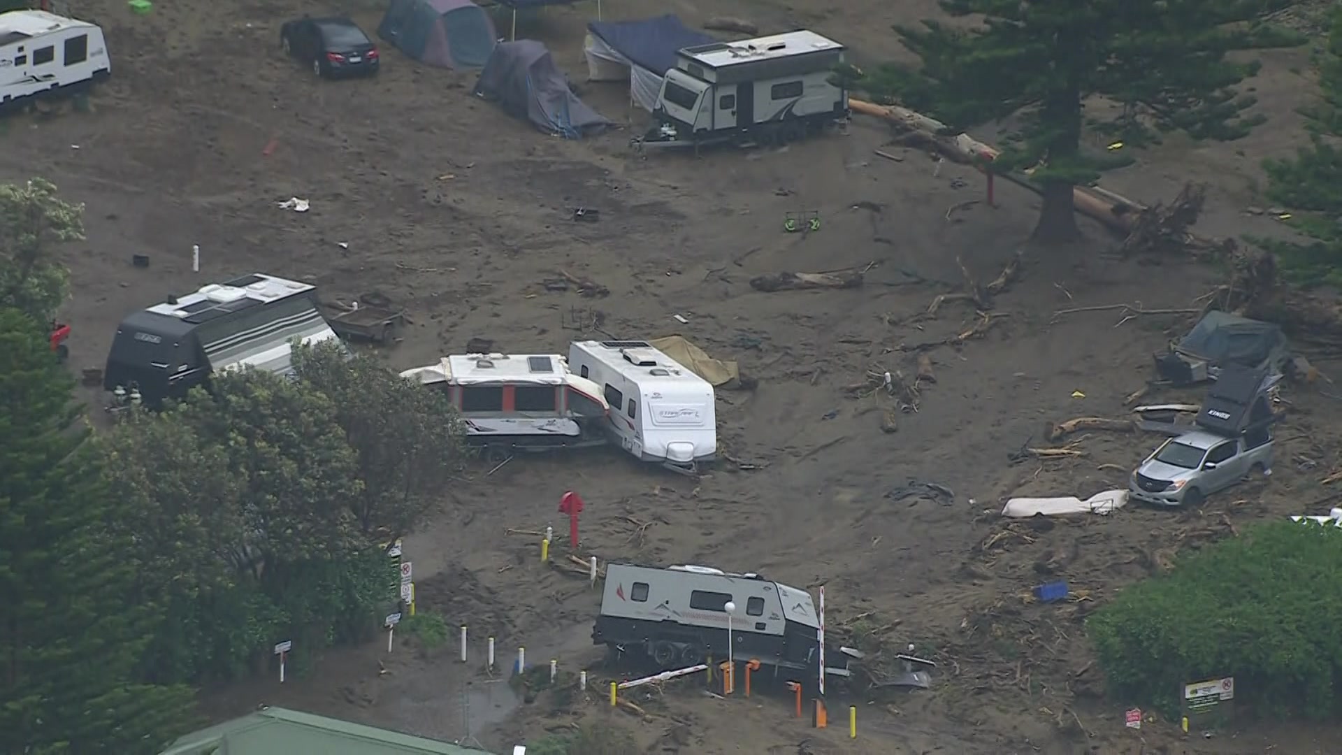 Vista aérea de caravanas abaladas e rodeadas de lama.