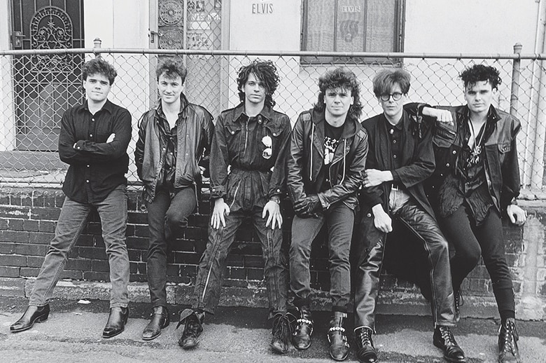 A black and white photo of a rock and roll band, dressed in leather.