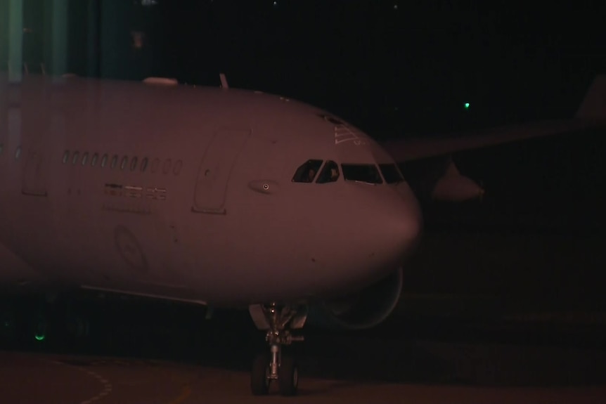 A plane moves along the tarmac in the dark