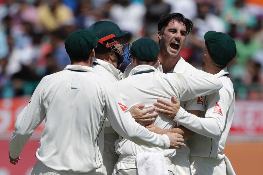 Australia's Pat Cummins with team-mates after dismissing India's KL Rahul on day two in Dharamsala.