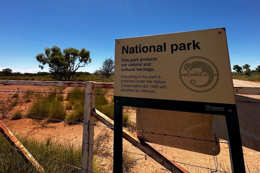 A National Park sign in front of a fence