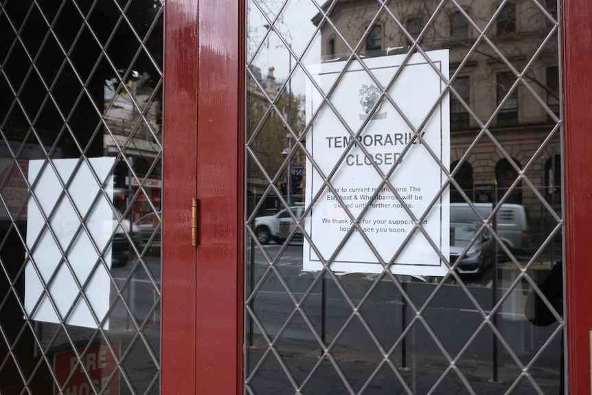 A sign on a window says a pub is temporarily closed.