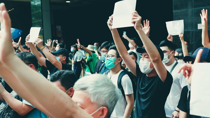 A crowd of protestors in Hong Kong raise white paper to avoid slogans which were banned under the national security law.