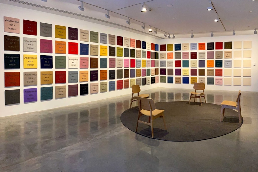 Knitted panels with the words "anonymous was a woman" in a gallery space