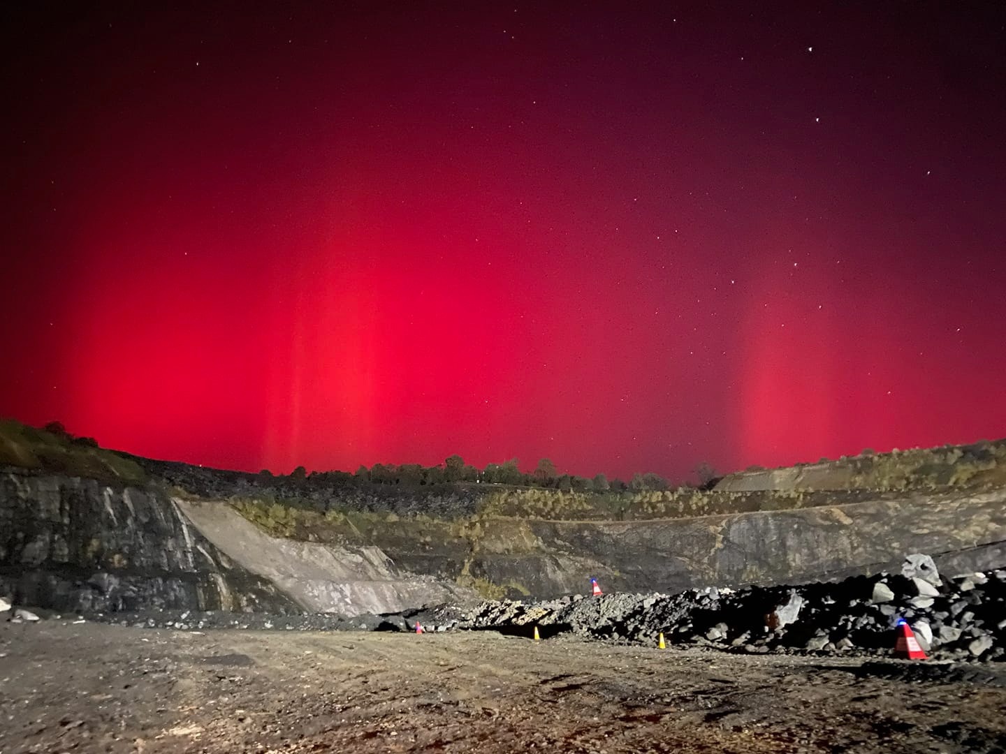 A gorgeous red sky over what looks like a mine or rubbish dump.