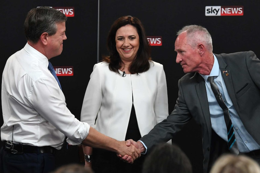 Steve Dickson shakes hands with Tim Nicholls, as Annastacia Palaszczuk watches on