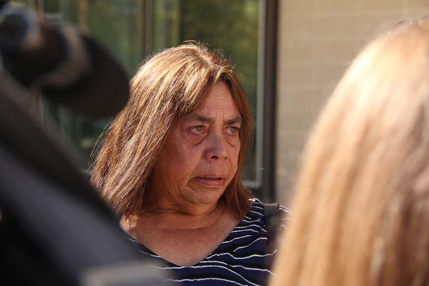 Steven Freeman's mother has tears in her eyes as she speaks to media outside court.