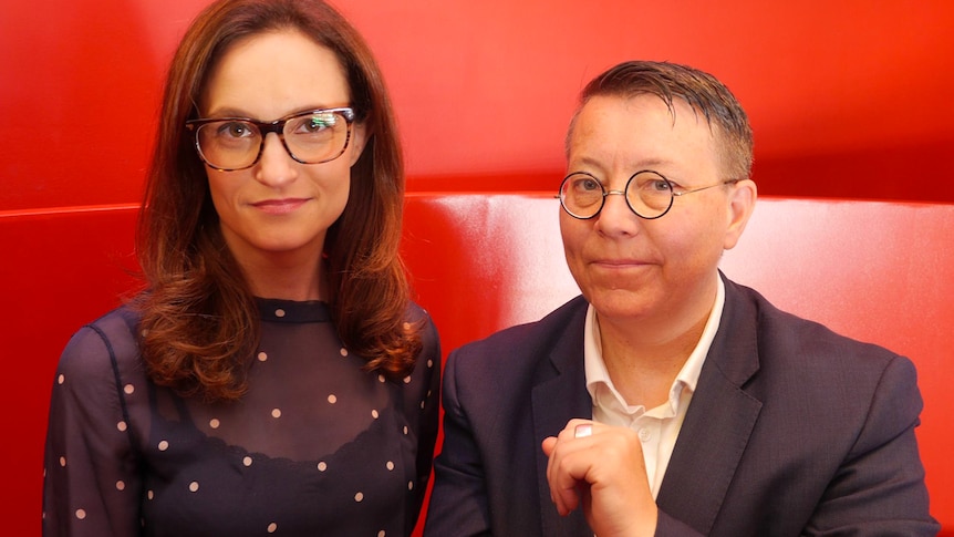 Elena Pappas (left) and Jill Prior (right) stand in front of a red backdrop.