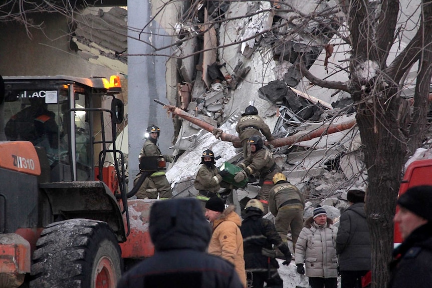 Emergency workers climb rubble in a bid to find survivors