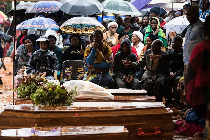 People attend the burial ceremony of some of the people who lost their lives following heavy rains caused by Cyclone Freddy.