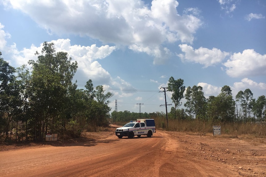 A police vehicle guards the scene where a fuel tank fell from a plane.