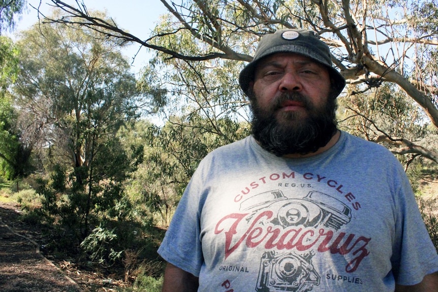 Barkindji man Murray Butcher stands on the banks of the Darling River in Wilcannia.
