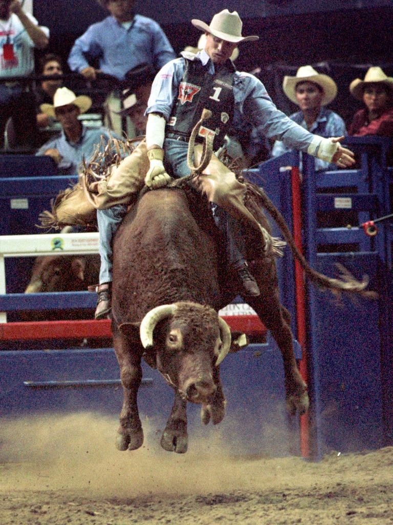 A man on a bucking bull.
