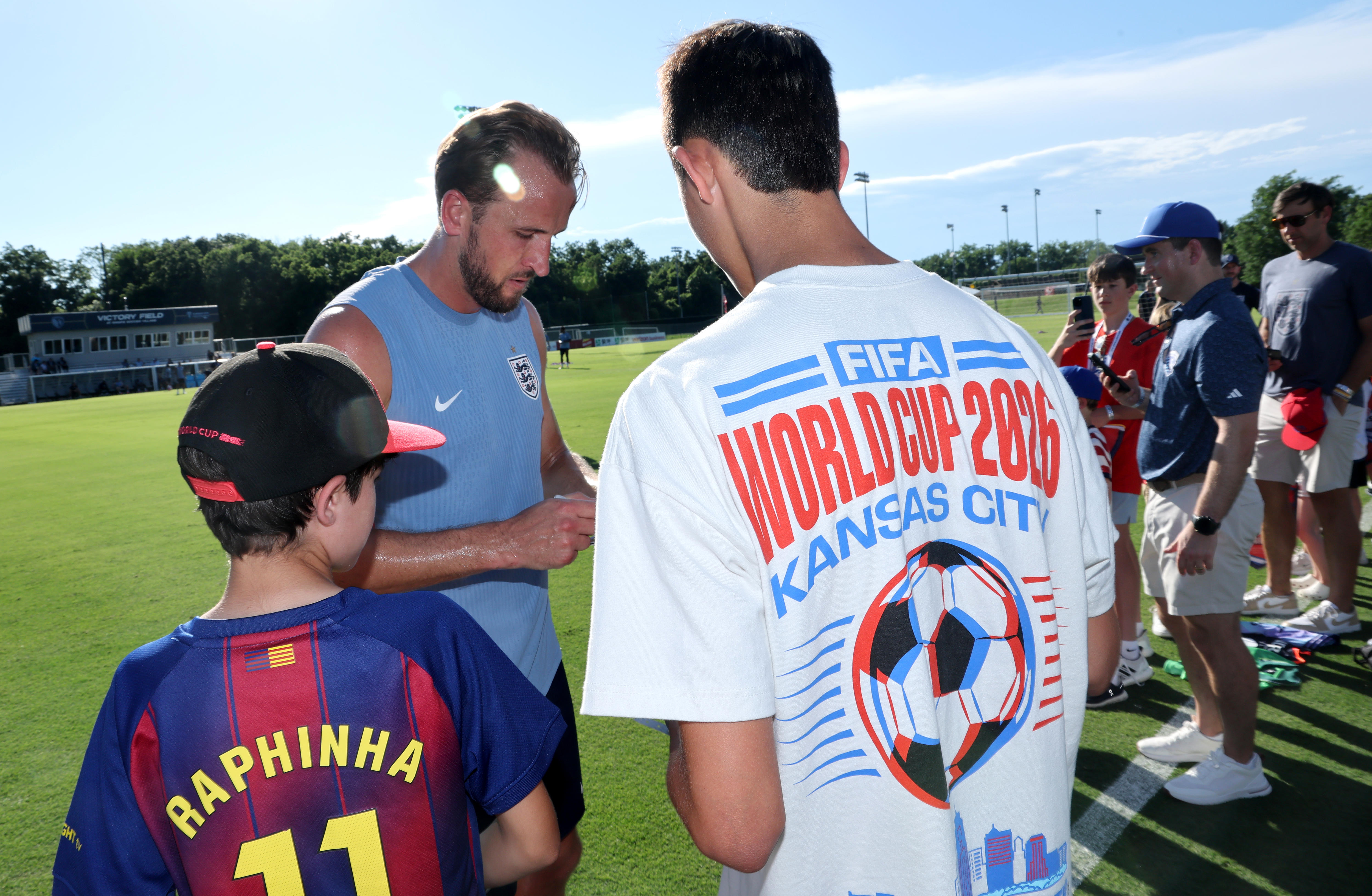 Harry Kane signs autgraphs for fans at an England training session