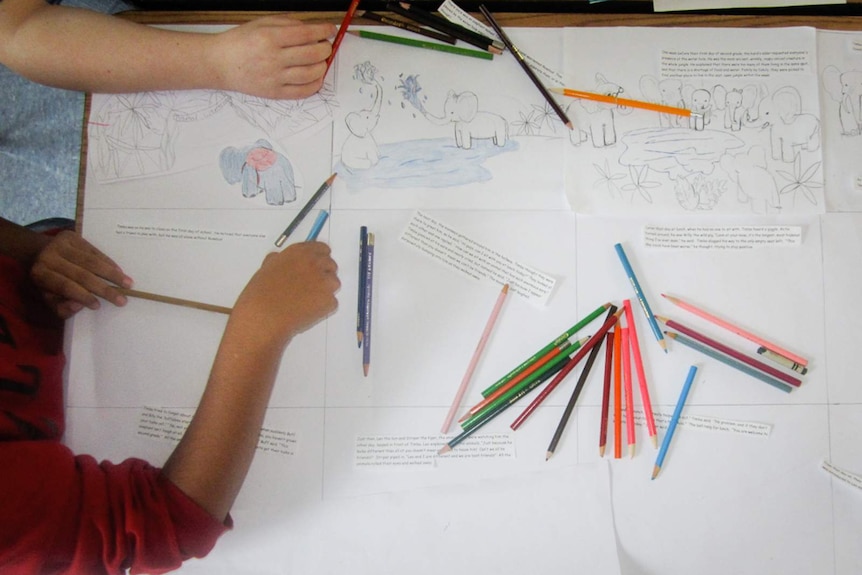 Children drawing elephants with pencils.