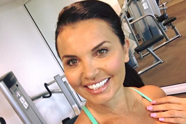 Ms Taylor takes a photo while wearing a green singlet in a gym.