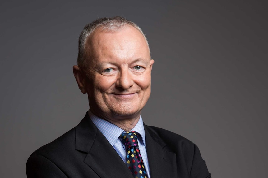 ABC election analyst Antony Green stands with his arms folded, smiling  in a profile photo
