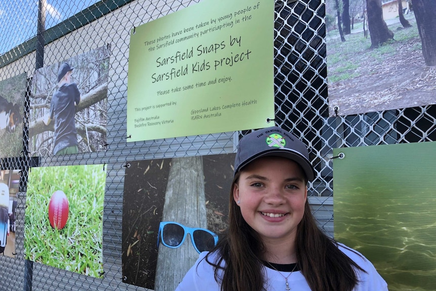 Ashley Wolf standing in front of photography exhibition at Sarsfield