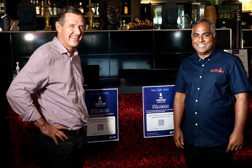 Michael Gunner and Saffrron Restaurant owner Selvan Kandasamy smile at the camera with a bar behind them.