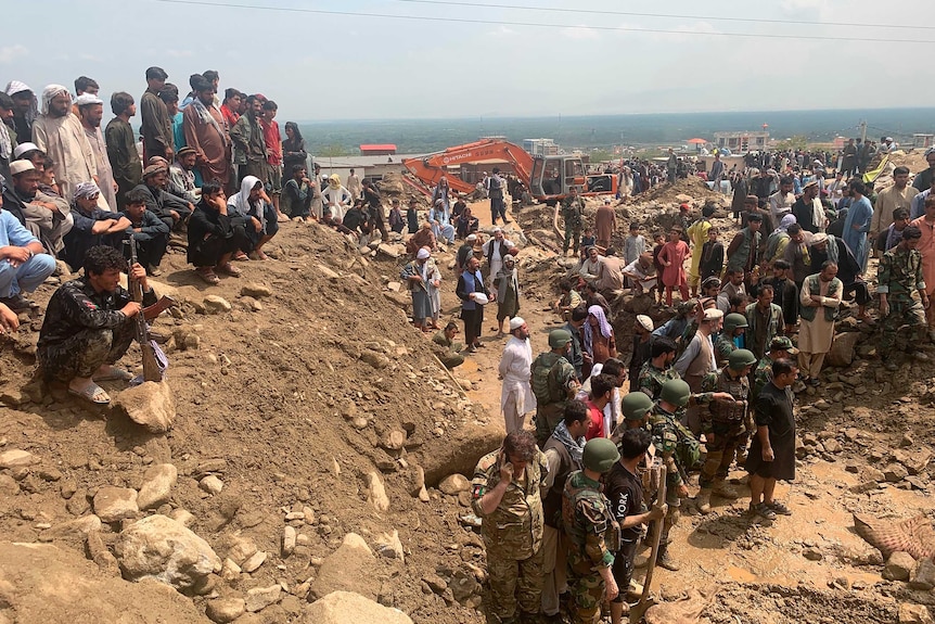 Soldiers and locals search for victims in a mudslide following heavy flooding in the Parwan province.