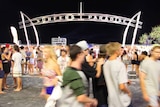 Crowds of people at the Surfers Paradise sign.