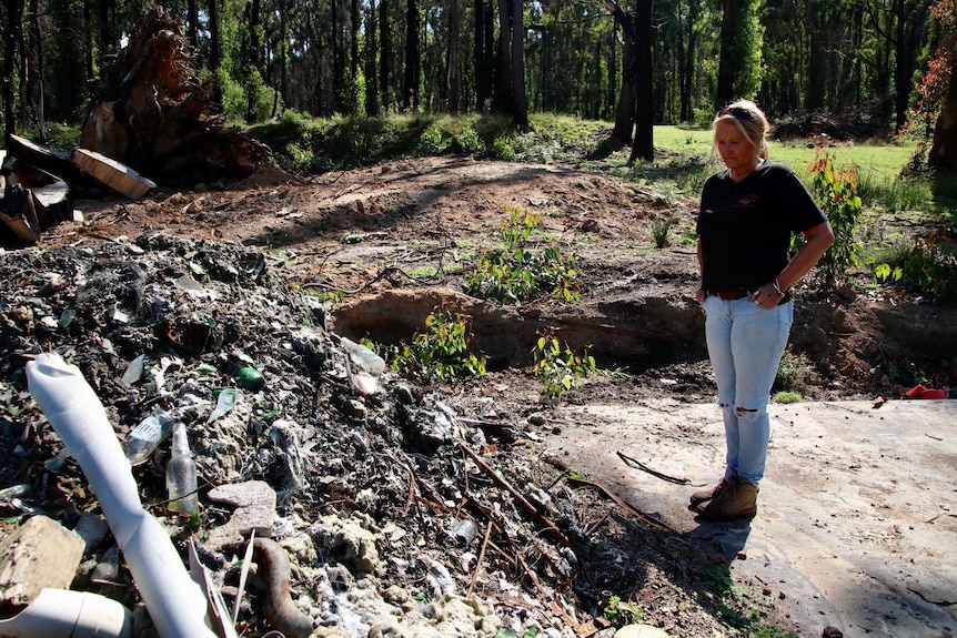 Karen Shift looks at the ruins of her home at Tonimbuk, Victoria.