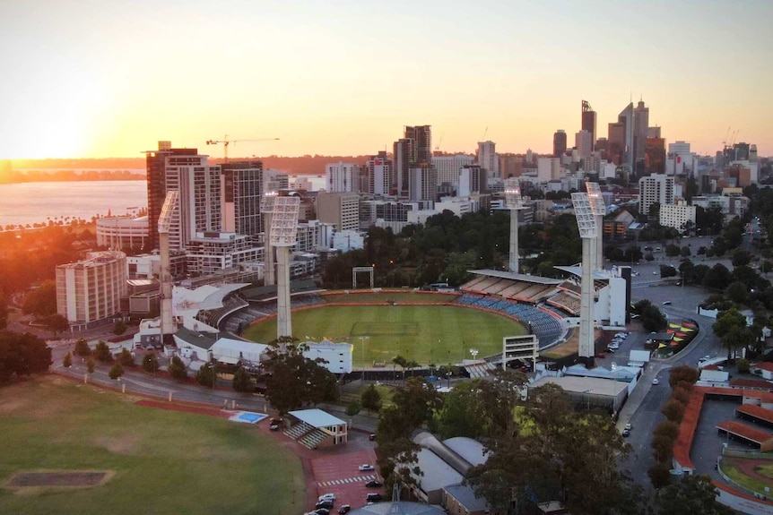 An aerial view of the WACA Ground at sunset with the Perth CBD in the background.