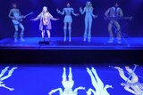 A fan sings with giant holograms of ABBA members.
