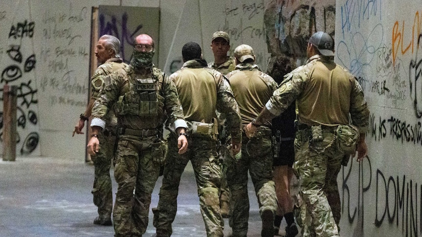 Federal officers pull a protester into the Federal Courthouse as protesters gather in downtown Portland, Oregon.