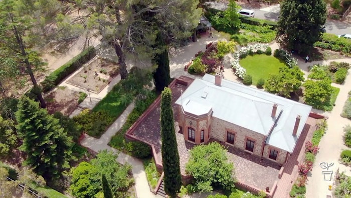 Aerial view of large house surrounded by formal garden