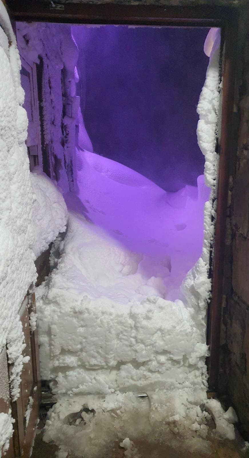 Deep snow blocking the front door of the Tan Hill Inn.