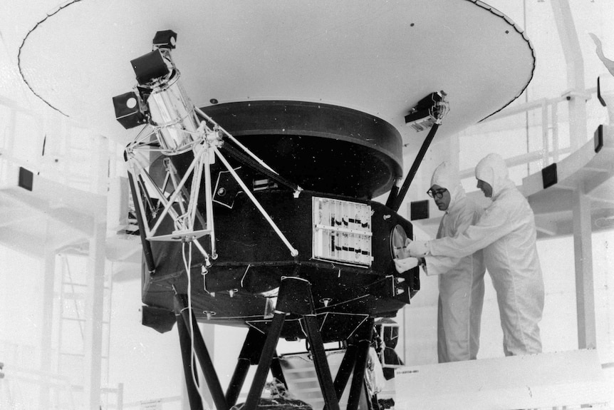 Black and white photo of men near satellite 