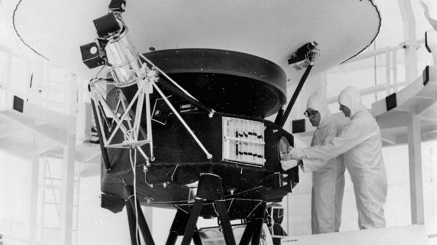 Black and white photo of men near satellite 
